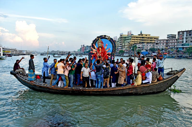 Hindu devotees immerse Durga Goddess into a river in Dhaka