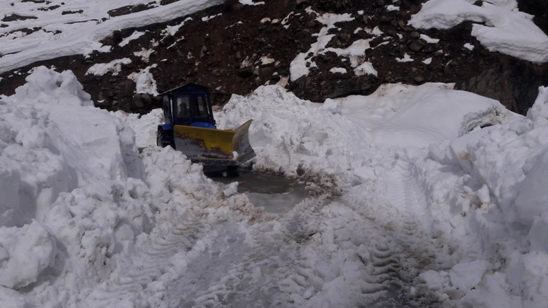 People walk through snow covered Bhaderwah-Chamba inter-state road in Kashmir