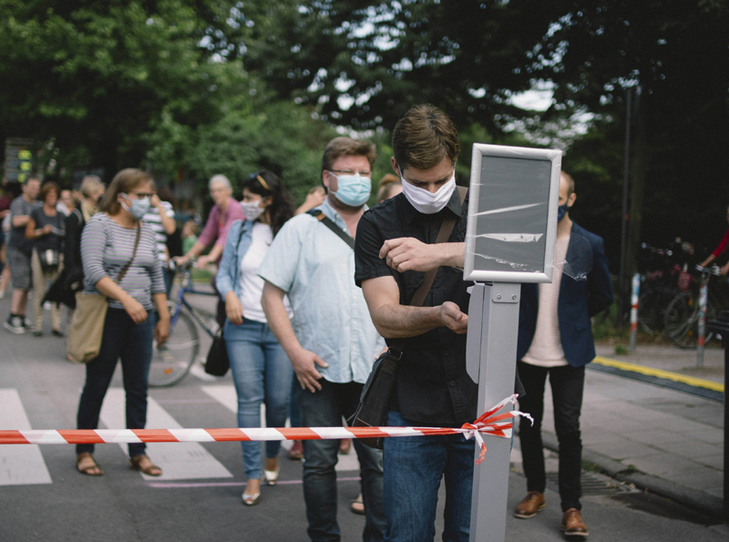 Customers line up to sanitize hands before entering a beer garden in Germany