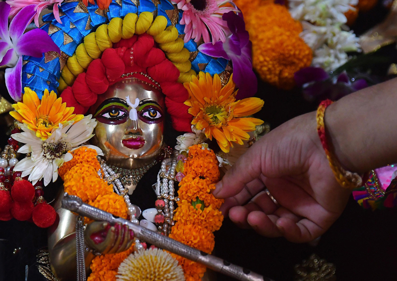 Janmasthami: A priest arranging the dress and ornaments of Lord Krishna