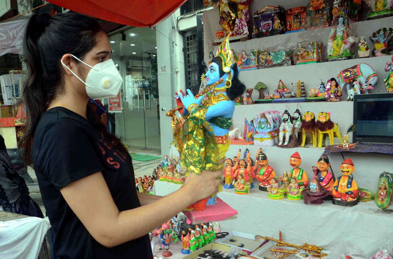 Janmasthami: A girl purchasing earthen idol of Lord Krishna