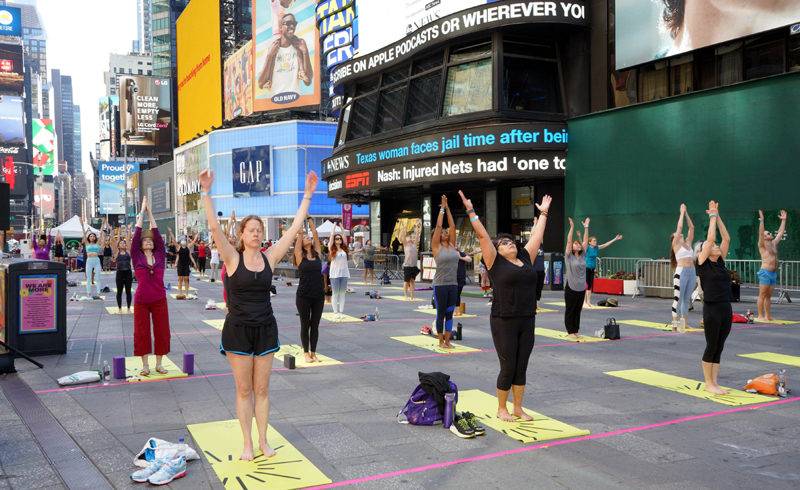 People practicing Yoga at Times Square