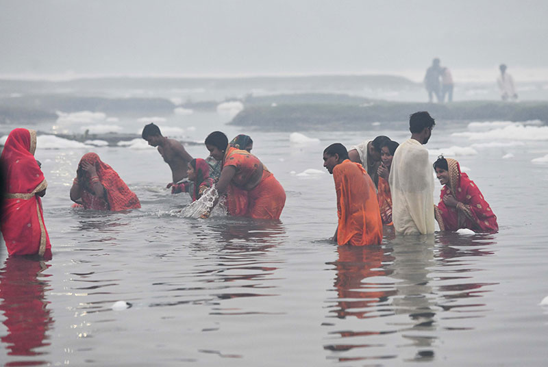 Devotees worship the rising sun at the banks of Yamuna in Delhi
