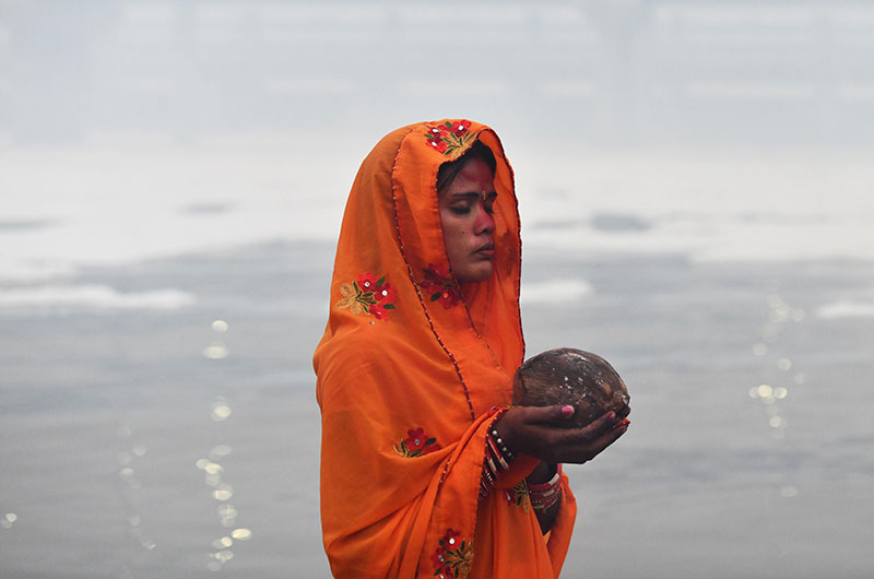 Devotees worship the rising sun at the banks of Yamuna in Delhi