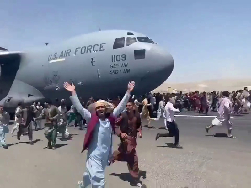 Glimpse of people running along US Air Force aircraft taking off from Kabul airport