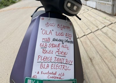 Ola scooter user places a placard on vehicle to urge people not to buy it