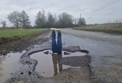 British man puts fake pair of legs in large pothole to highlight problem of his village