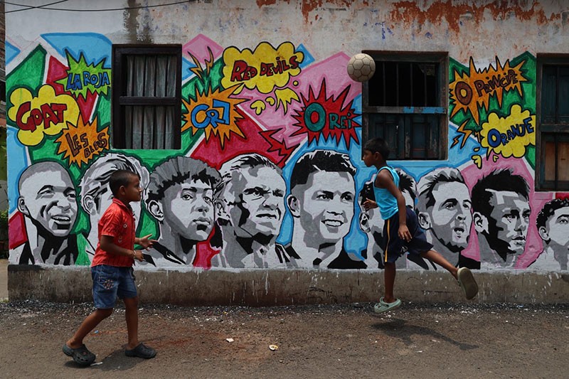 In Images: Children in Kolkata play against the backdrop of a giant World Cup masterpiece